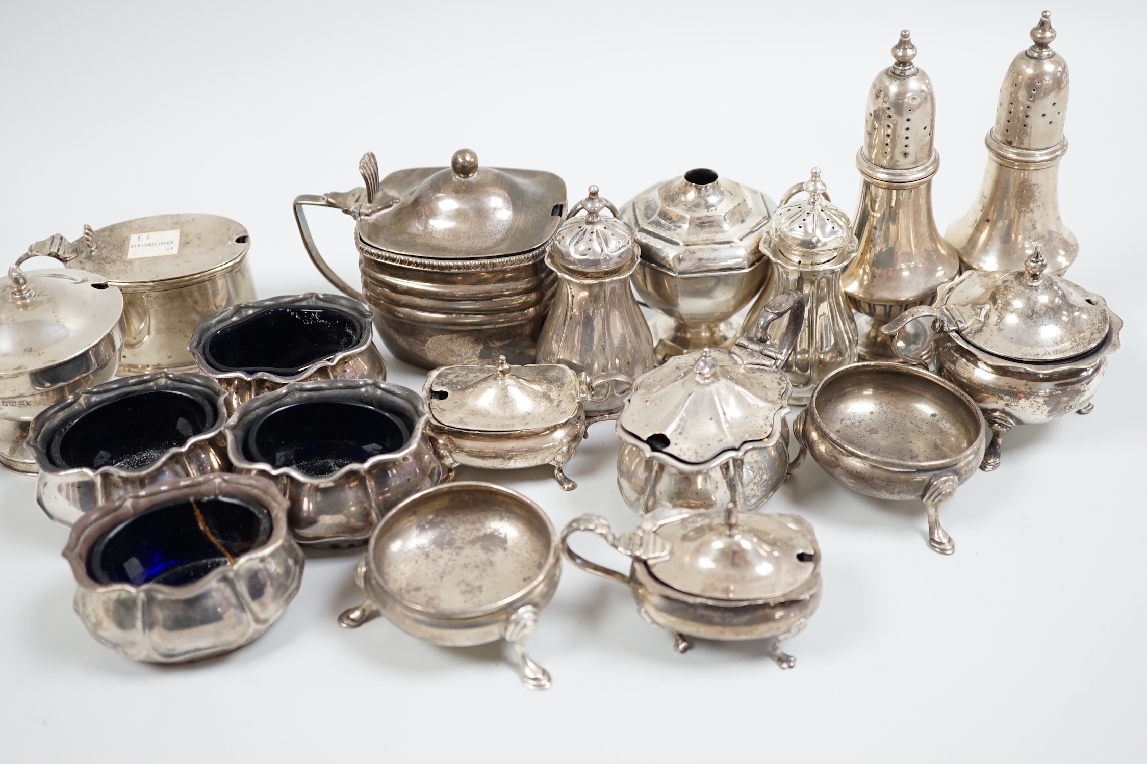 An Edwardian seven piece silver condiment set, Atkin Bros. Sheffield, 1903/4 and eleven other silver condiments including a pair of pepperettes.